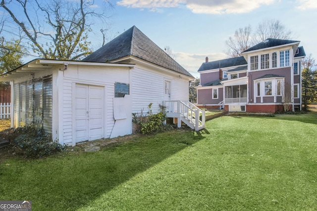 rear view of house with a lawn and a sunroom