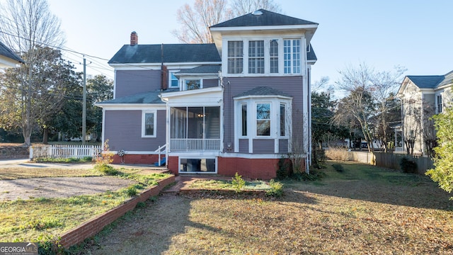 view of front facade featuring a front yard and a sunroom