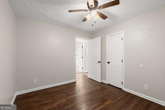 unfurnished bedroom with ceiling fan, dark hardwood / wood-style floors, and a textured ceiling