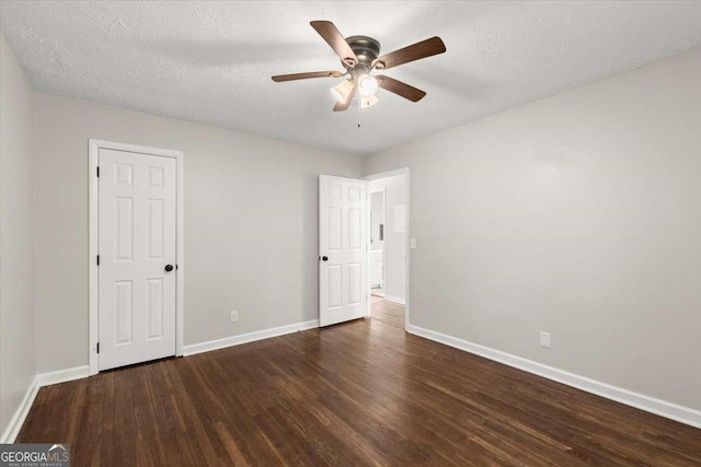 empty room featuring a textured ceiling, dark hardwood / wood-style flooring, and ceiling fan