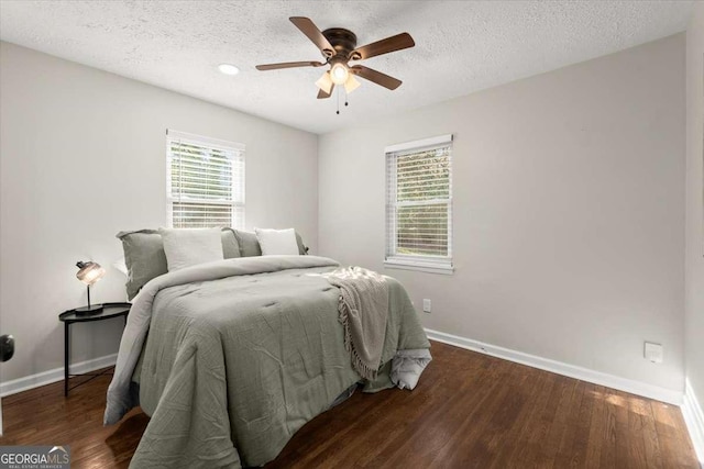 bedroom featuring a textured ceiling, ceiling fan, and dark wood-type flooring