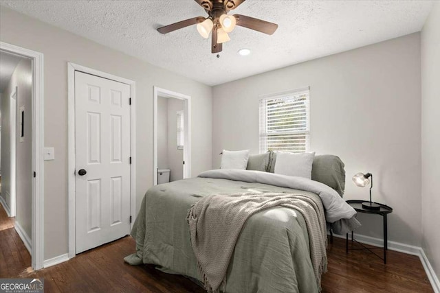 bedroom with a textured ceiling, ensuite bath, ceiling fan, and dark hardwood / wood-style floors