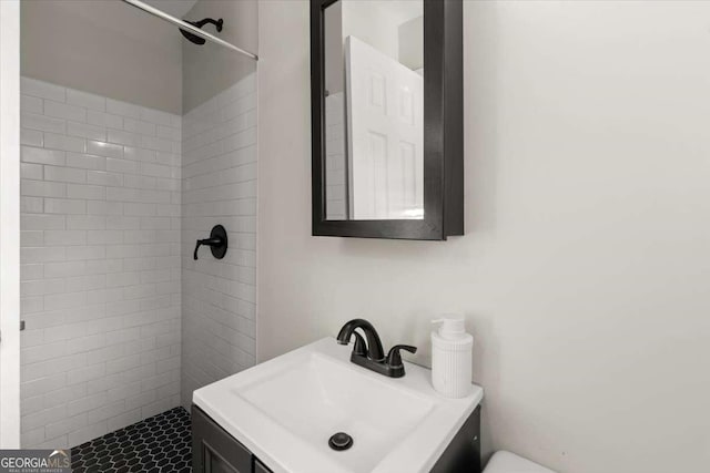 bathroom with vanity and a tile shower