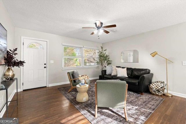 living room featuring a textured ceiling, ceiling fan, and dark hardwood / wood-style floors