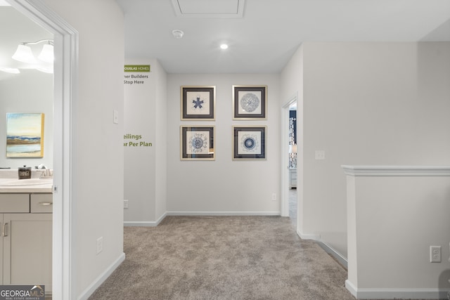 corridor with light carpet and sink