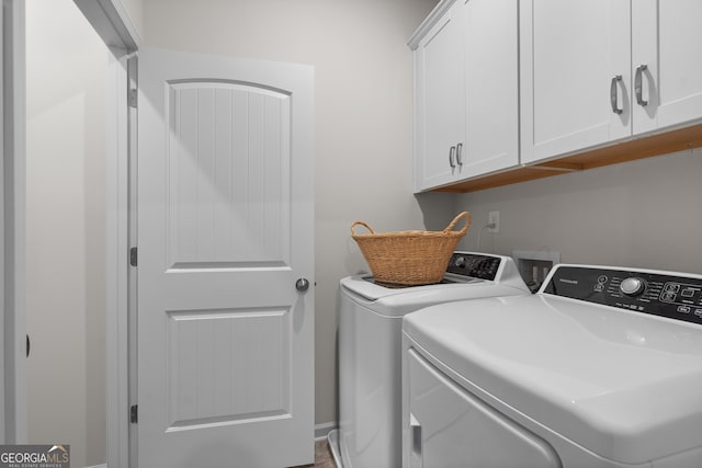 washroom featuring cabinets and washing machine and clothes dryer