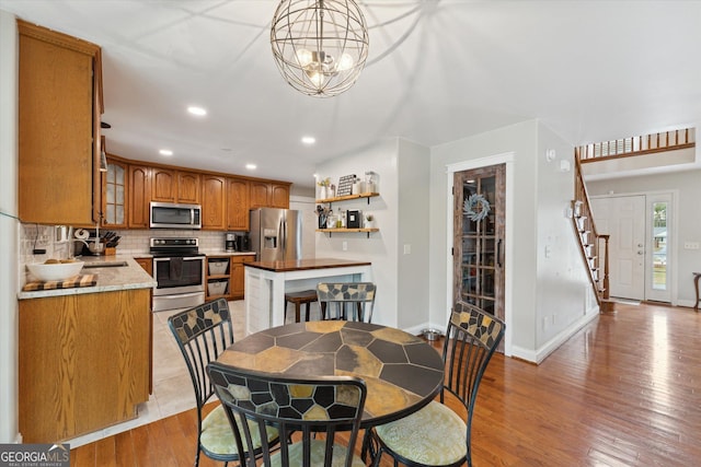 dining space featuring a chandelier, sink, and light hardwood / wood-style floors