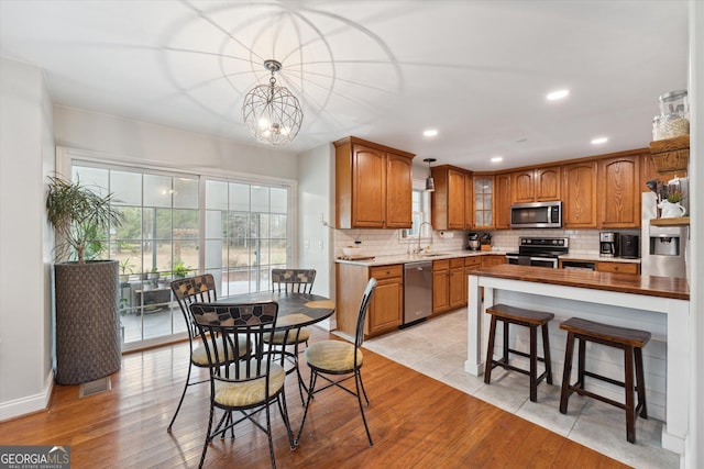 kitchen featuring a chandelier, sink, light hardwood / wood-style floors, and appliances with stainless steel finishes