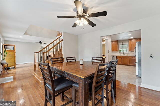 dining room with ceiling fan and light hardwood / wood-style flooring