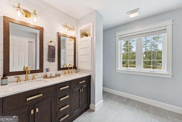 bathroom featuring tile patterned flooring, vanity, and wood walls