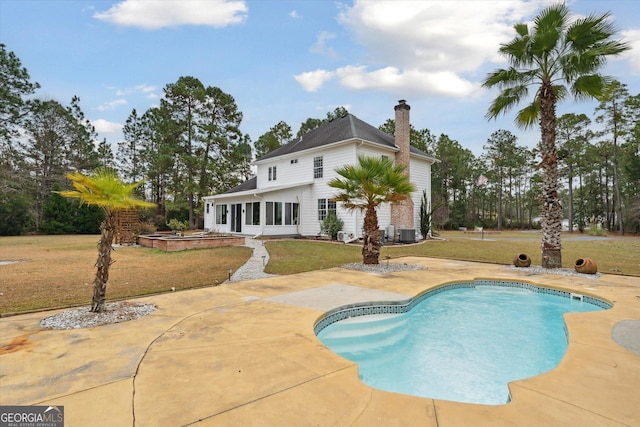 view of pool with central air condition unit, a patio area, and a lawn