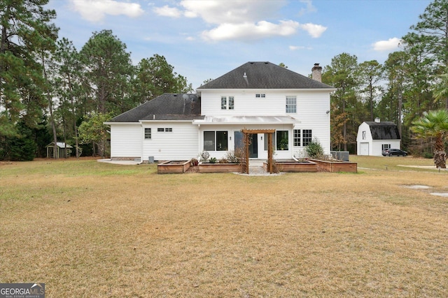 rear view of house with a shed, a yard, and central AC