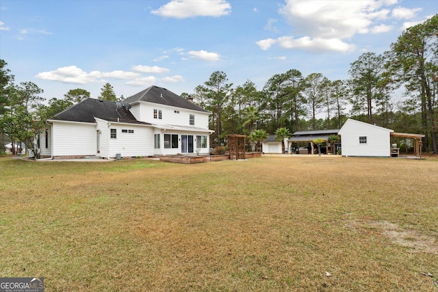 back of property with a lawn and a carport