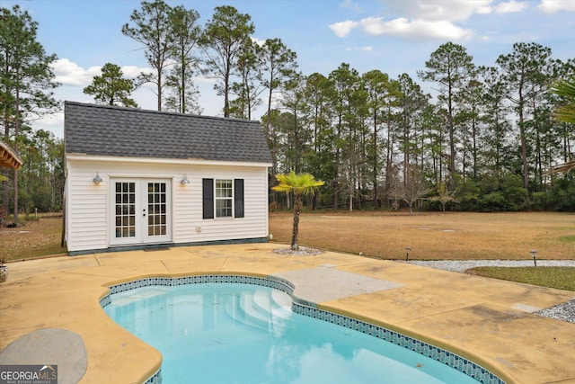 view of pool featuring a patio area, french doors, and an outdoor structure