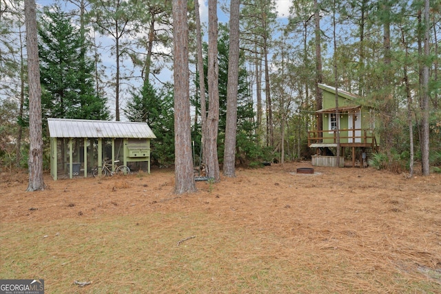 view of yard with an outdoor structure and a wooden deck