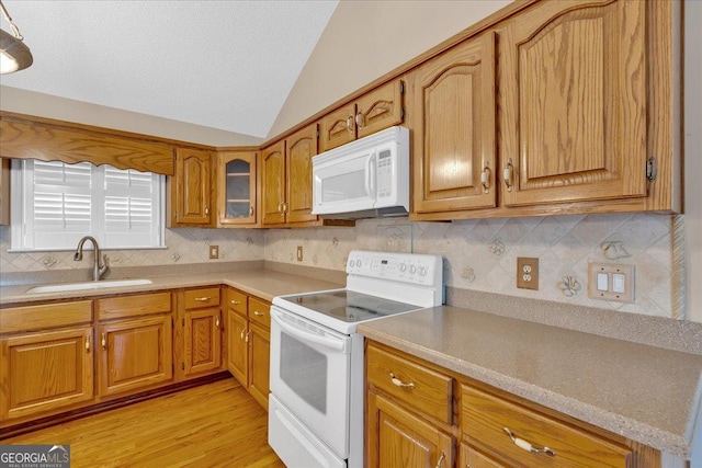 kitchen featuring light wood-type flooring, white appliances, sink, and vaulted ceiling