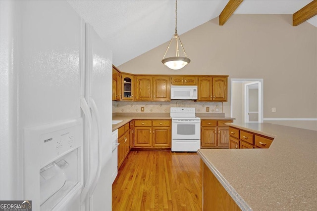 kitchen featuring beamed ceiling, decorative light fixtures, white appliances, and light wood-type flooring