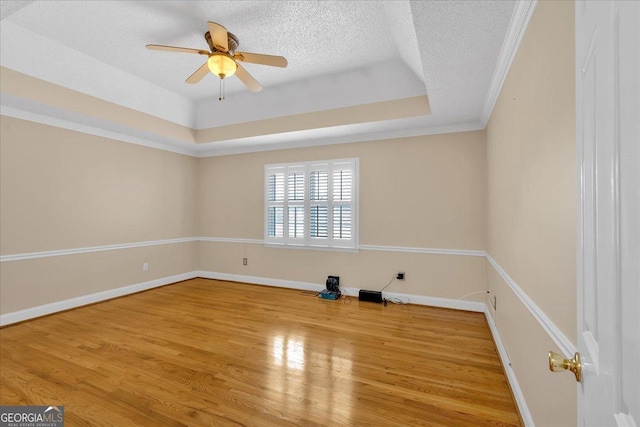 unfurnished room featuring ceiling fan, wood-type flooring, a textured ceiling, and ornamental molding