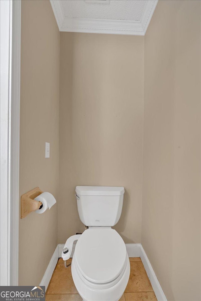 bathroom with tile patterned flooring, toilet, crown molding, and a textured ceiling