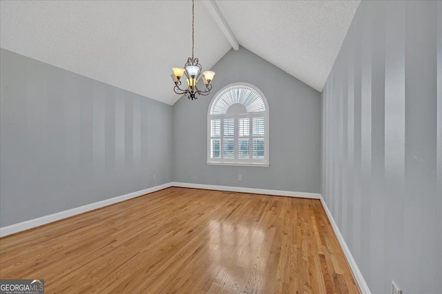 unfurnished room with a textured ceiling, vaulted ceiling with beams, an inviting chandelier, and light hardwood / wood-style flooring