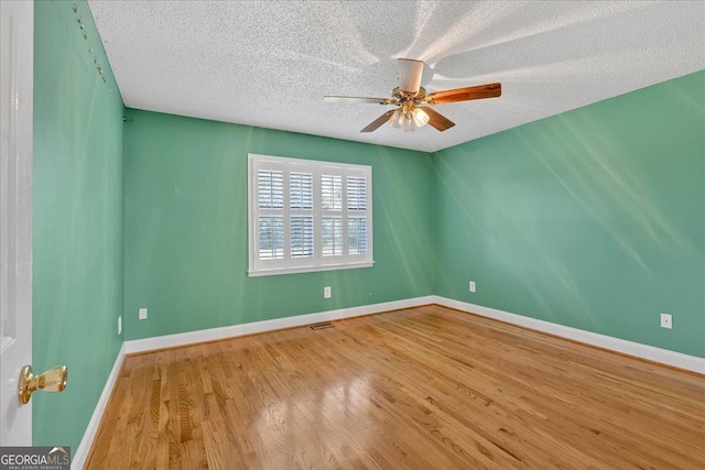 unfurnished room featuring hardwood / wood-style floors, ceiling fan, and a textured ceiling