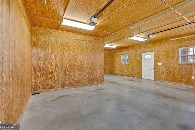 interior space featuring a garage door opener and wooden walls