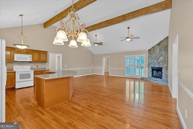 kitchen featuring white appliances, a stone fireplace, hanging light fixtures, light hardwood / wood-style flooring, and beamed ceiling