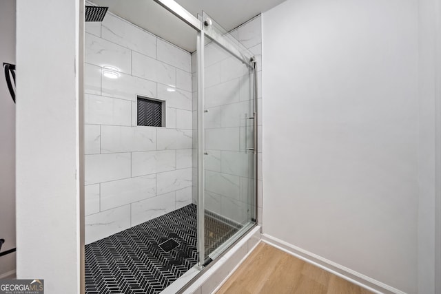 bathroom with an enclosed shower and hardwood / wood-style flooring