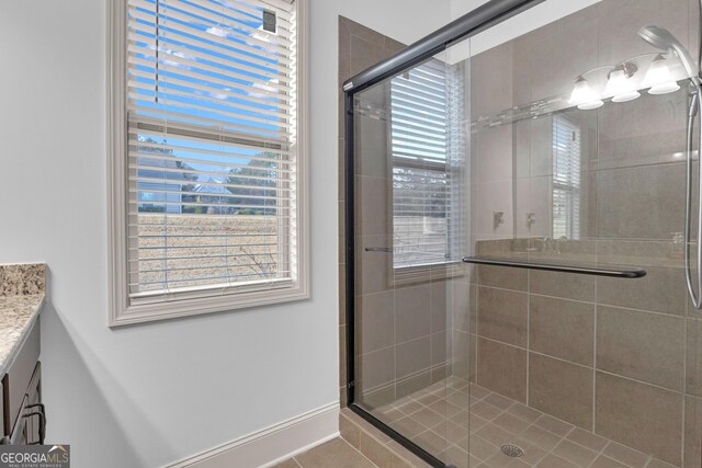 bathroom featuring tile patterned floors, vanity, and walk in shower