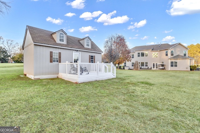 back of property featuring a lawn and a wooden deck