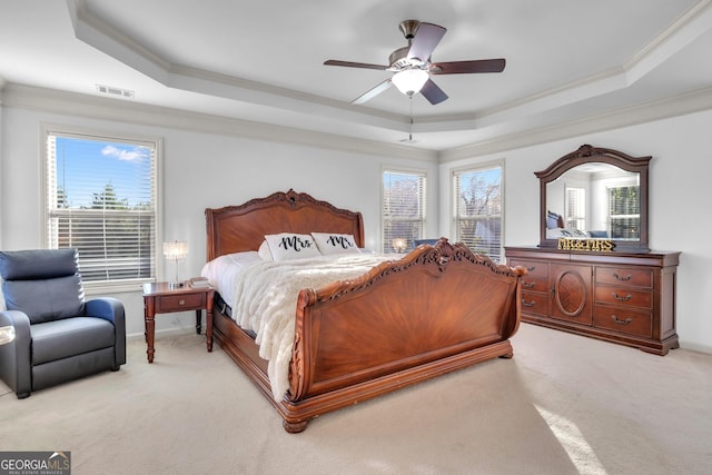 bedroom featuring light carpet, a raised ceiling, and ceiling fan