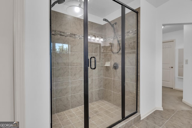 bathroom with tile patterned floors and a shower with door