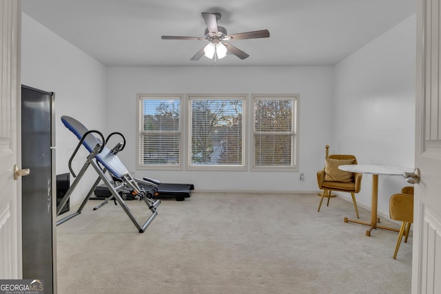 workout room featuring ceiling fan and light colored carpet