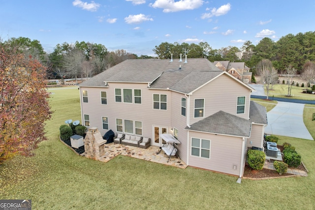 rear view of property featuring a yard, a patio area, and outdoor lounge area