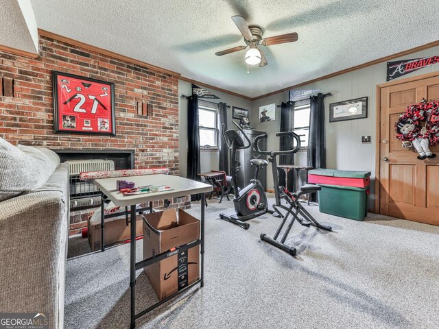 workout area with a textured ceiling, ceiling fan, carpet floors, and ornamental molding