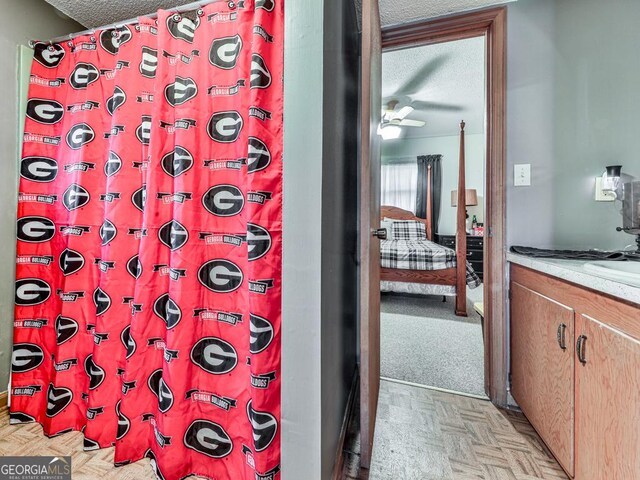 bathroom with parquet floors, vanity, a textured ceiling, and a shower with shower curtain