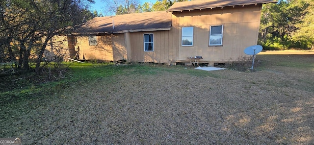 rear view of property featuring a lawn