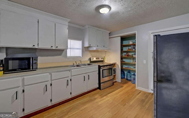 kitchen featuring light hardwood / wood-style flooring, white cabinets, stainless steel appliances, and sink