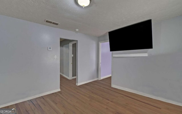 empty room featuring hardwood / wood-style flooring and a textured ceiling