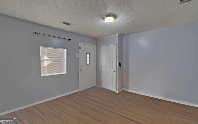 entryway featuring wood-type flooring and a textured ceiling