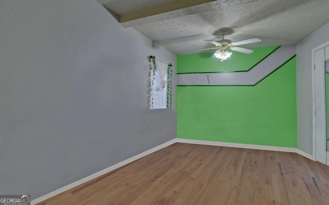 spare room with vaulted ceiling with beams, a textured ceiling, and light wood-type flooring