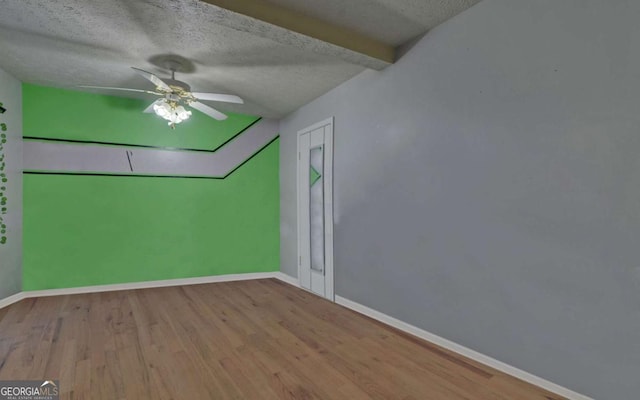 unfurnished room featuring light hardwood / wood-style flooring, lofted ceiling with beams, and a textured ceiling