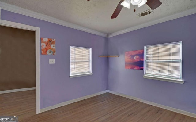 spare room featuring ceiling fan, crown molding, wood-type flooring, and a textured ceiling