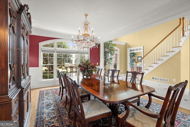 dining room featuring decorative columns, hardwood / wood-style flooring, and ornamental molding