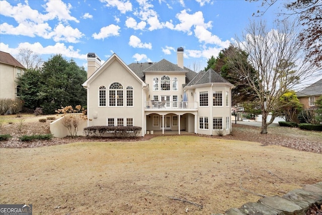 view of front of home featuring a balcony and a front lawn