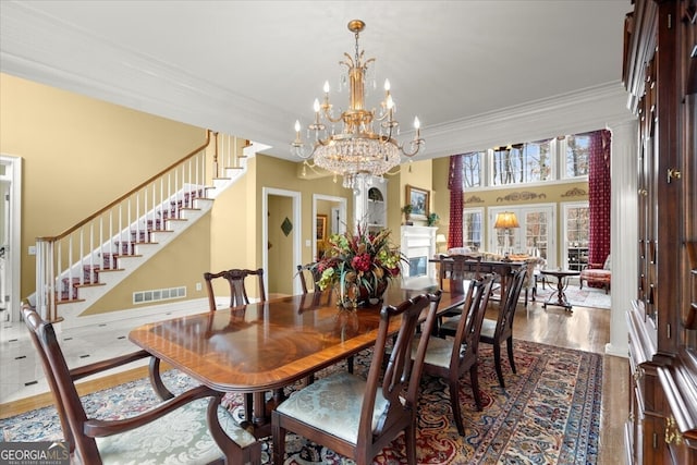 dining room featuring crown molding, a chandelier, a high ceiling, and hardwood / wood-style flooring