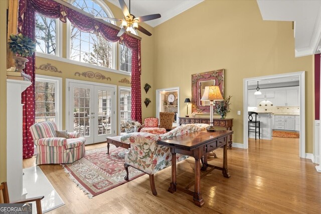 living room with a healthy amount of sunlight, light hardwood / wood-style flooring, and french doors