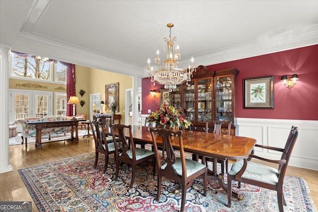 dining room featuring ornate columns, french doors, and wood-type flooring