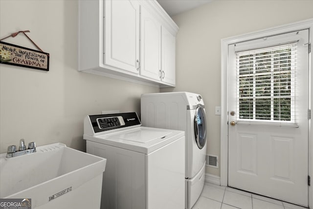 washroom featuring sink, light tile patterned floors, cabinets, and independent washer and dryer