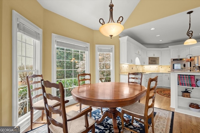 dining room featuring light hardwood / wood-style floors and vaulted ceiling